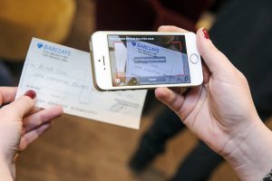 A mobile phone taking a picture of a cheque