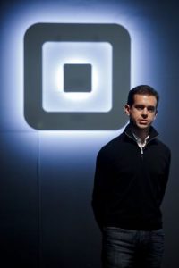 Jack Dorsey stood infront of Square logo