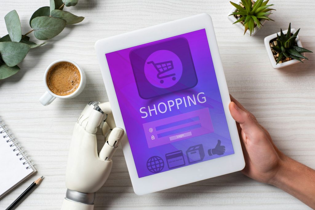cropped image of man with prosthesis hand using digital tablet with shopping on screen at table with