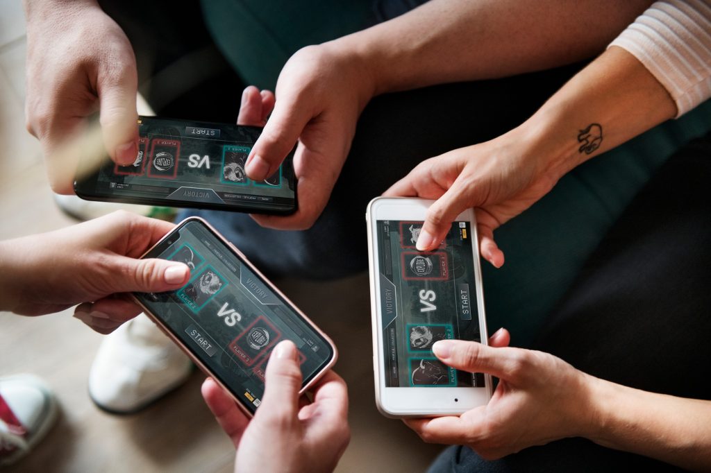Group of diverse friends playing game on mobile phone